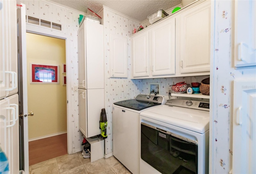 Amazing large washer and dryer in this huge laundry room with plenty of storage.