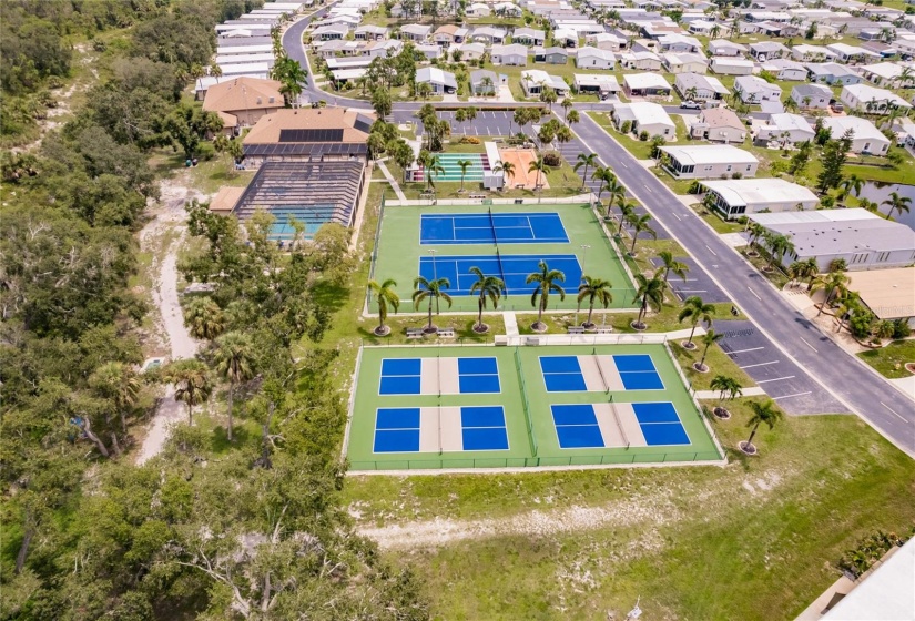 Aerial of the Community. Burnt Store Colony Resident Owned, 55+ gated community is highly sought after, with only 236 manufactured beautiful homes located on Burnt Store Road, in Punta Gorda, Florida. In 2022 the Southwest Gulf Coast Community Association Institute voted Burnt Store Colony one of the top three South West Gulf Coast communities in which to live. Major activities, Heated, screened pool and spa. Club house has smaller, multi functional building, Kitchen, Dining area, Pool tables, ping pong tables, storage area, library with games tables and chairs, fitness center, hallway event center bulletin board. New Banquet Hall with industrial kitchen, ceiling projector with computer display on large screen. Large smart TV/VCR with internet. Used for morning coffee, dinners, dances, bingo and major social activities, restrooms and more.ds with major activities, access to the huge screened, heated pool and spa, restrooms and much more.