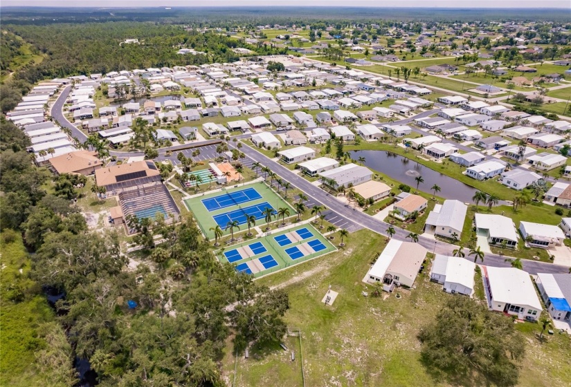 Aerial of the Community. Burnt Store Colony Resident Owned, 55+ gated community is highly sought after, with only 236 manufactured beautiful homes located on Burnt Store Road, in Punta Gorda, Florida. In 2022 the Southwest Gulf Coast Community Association Institute voted Burnt Store Colony one of the top three South West Gulf Coast communities in which to live. Major activities, Heated, screened pool and spa. Club house has smaller, multi functional building, Kitchen, Dining area, Pool tables, ping pong tables, storage area, library with games tables and chairs, fitness center, hallway event center bulletin board. New Banquet Hall with industrial kitchen, ceiling projector with computer display on large screen. Large smart TV/VCR with internet. Used for morning coffee, dinners, dances, bingo and major social activities, restrooms and more.ds with major activities, access to the huge screened, heated pool and spa, restrooms and much more.