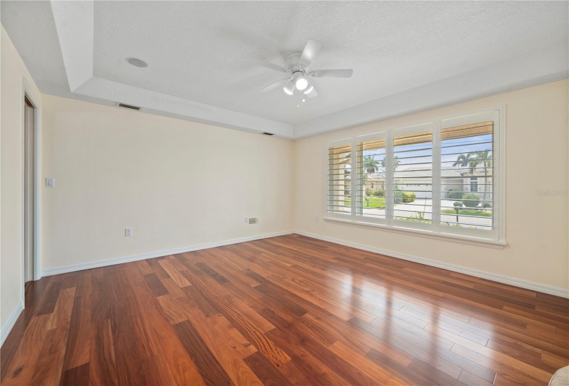 Light filled formal Dining Room has tray ceiling & plantation shutters