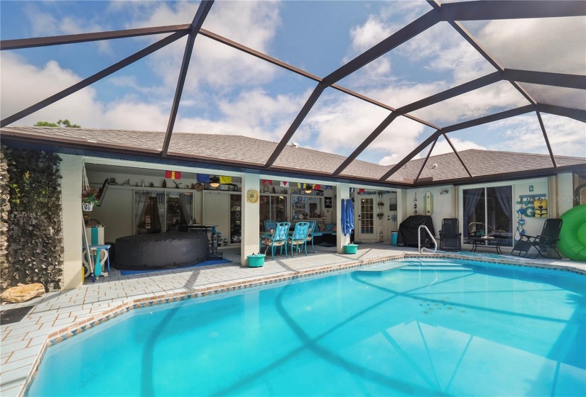 Large pool and hot tub in covered lanai area