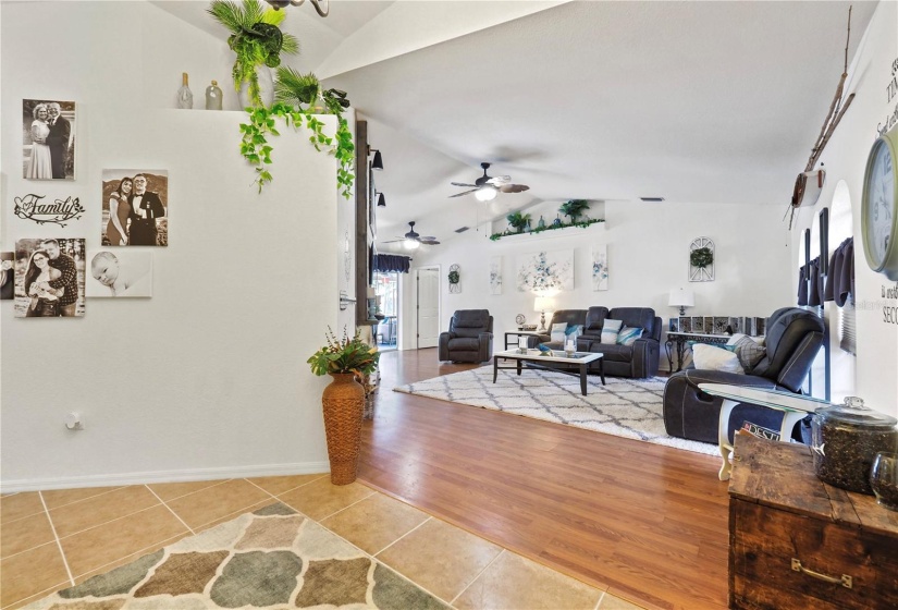 Livings room/family room with vaulted ceilings and ceiling fans.