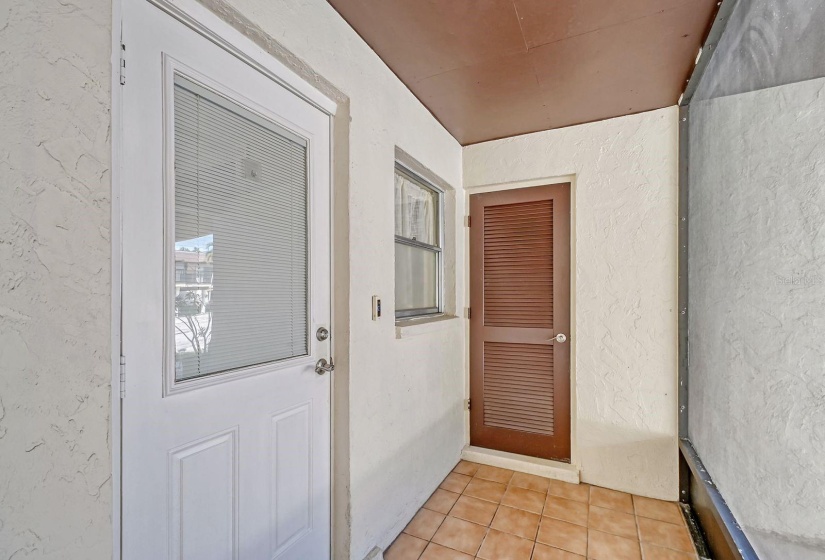 Screened Entryway with Entry Door to the Utility Room with a Washer & Dryer.