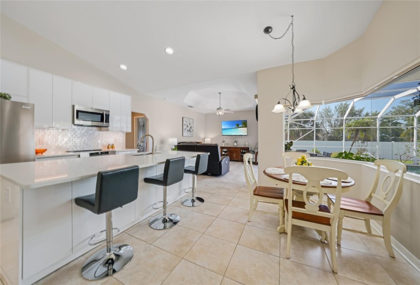 open kitchen and family room with dinette. Large window overlooking lanai and pool. More storage under island pictured here.