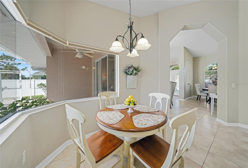 Dinette area with large picture window overlooking pool and spa. Dining room and front door pictured in center back here.