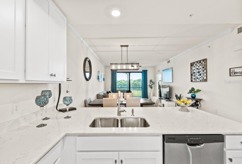 Gourmet kitchen featuring quartz countertops, stainless steel appliances, wood shaker cabinets, a breakfast bar, and island.