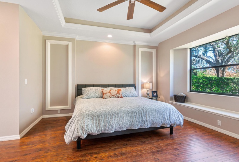 Owners suite featuring laminate wood look flooring, two walk-in closets, and an ensuite bathroom.