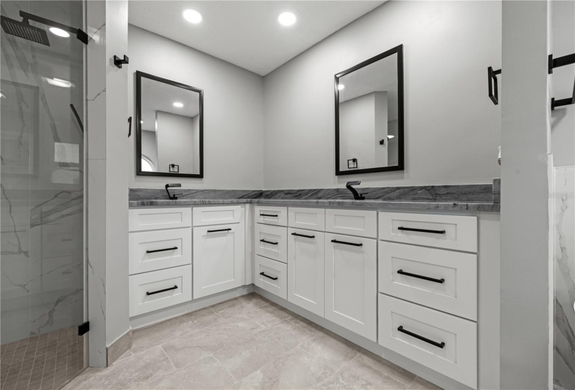 Luxurious walk-in shower with seat, dual sinks, solid stone counters and designer type faucets