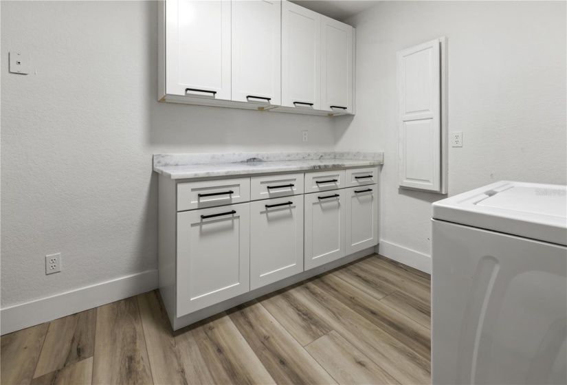 Dreamy Laundry Room with cabinet storage and shelving