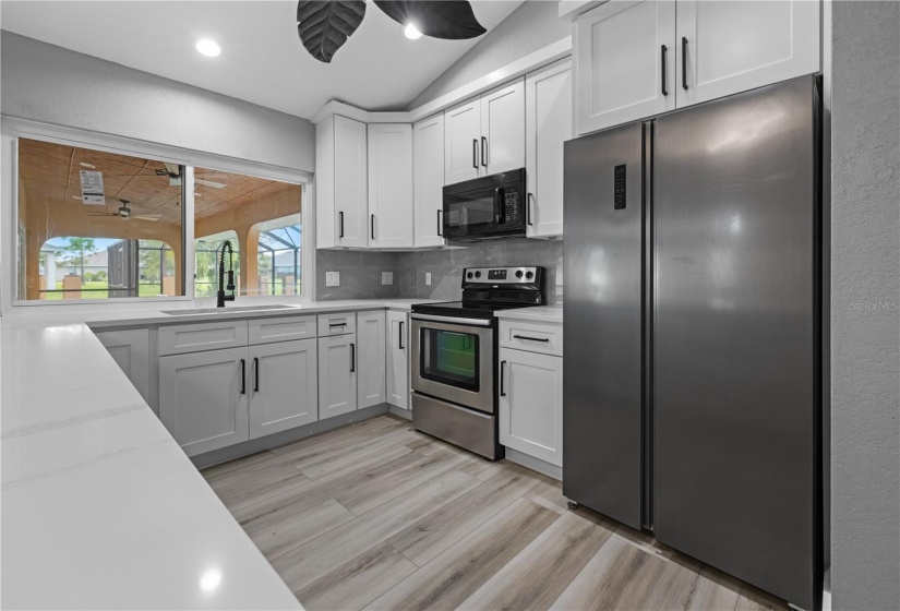 Chef's dream all wrapped up in this kitchen! Solid stone granite counters, white shaker cabinets with black hardware, double door closet pantry and stainless appliances