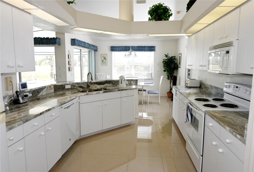 Kitchen with adjacent dinette which has sliders to the pool area