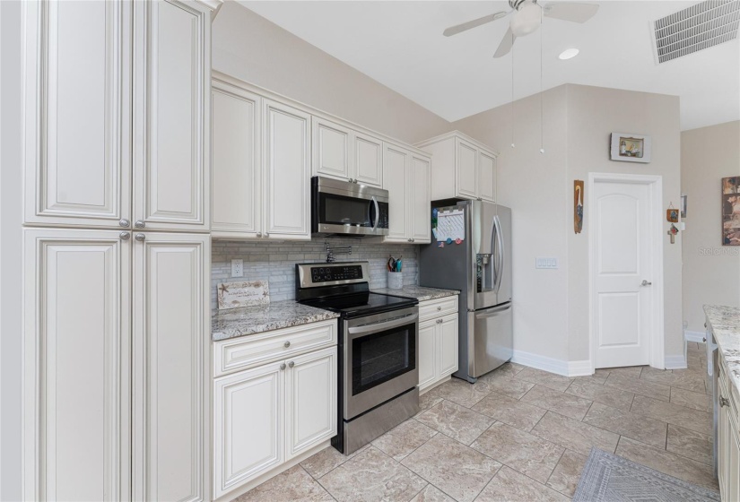 Solid wood cabinets with stylish backsplash.  Pot filler above range