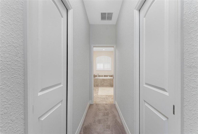 Walk-in closets on either side of the entry into ensuite bathroom