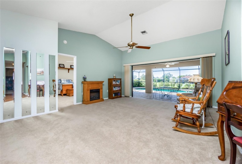 Living room with cathedral ceiling.  Beautiful view of the lanai, pool and greenbelt.