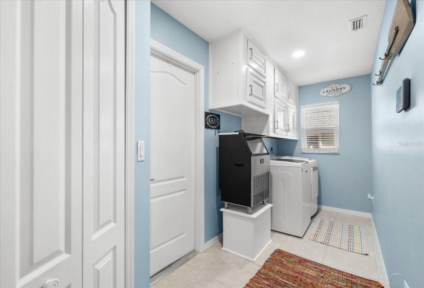 Indoor laundry with cabinets and storage closets