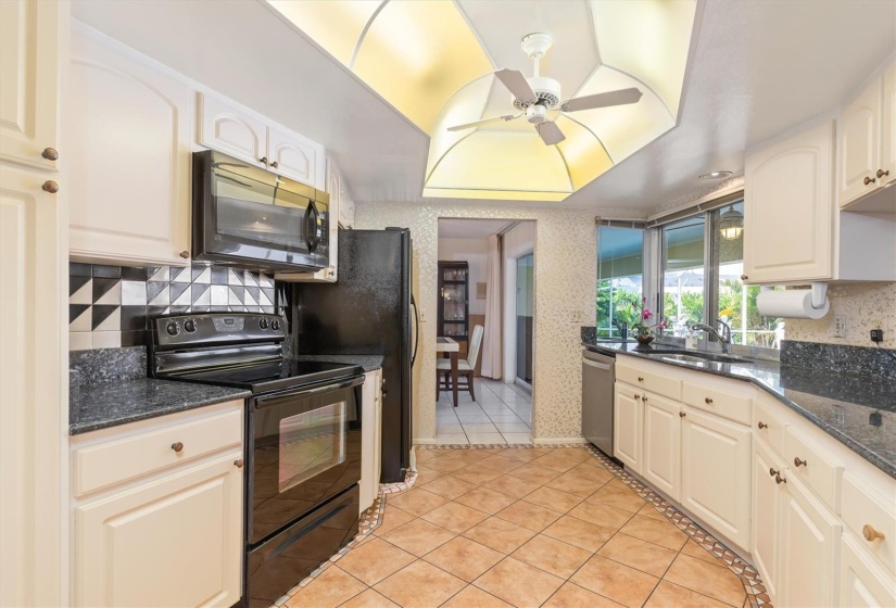 The kitchen adjoins the dining room in the background as well as the family room opposite the breakfast bar.