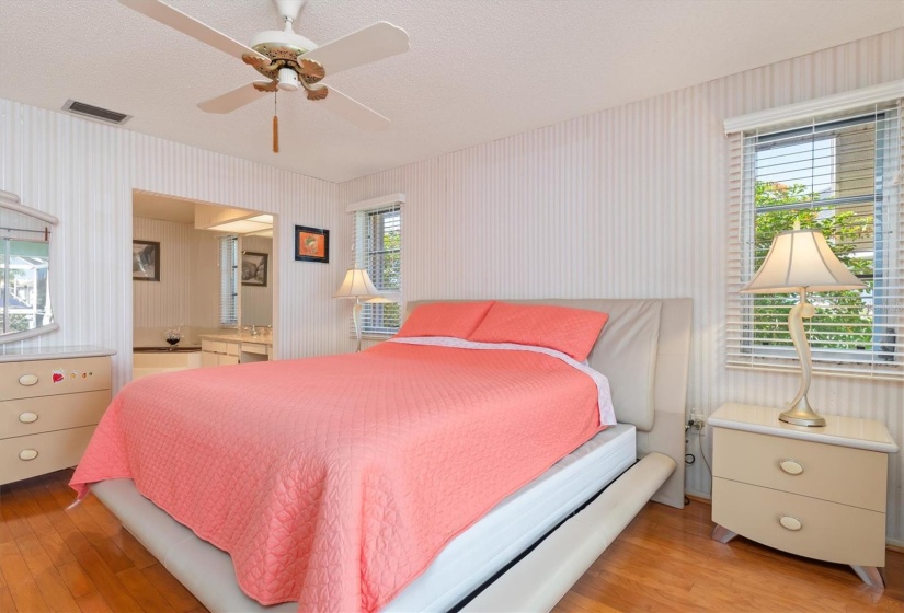 Ensuite tiled bathroom includes dual vanities and sinks, a jetted tub, private water closet with shower, and a  spacious walk-in closet.