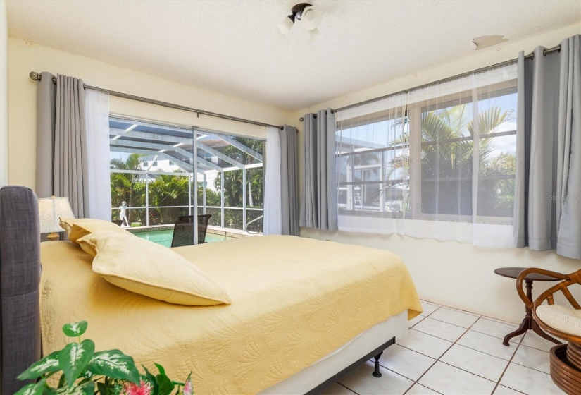 Tiled guest bedroom with slider access to lanai/pool/sauna.