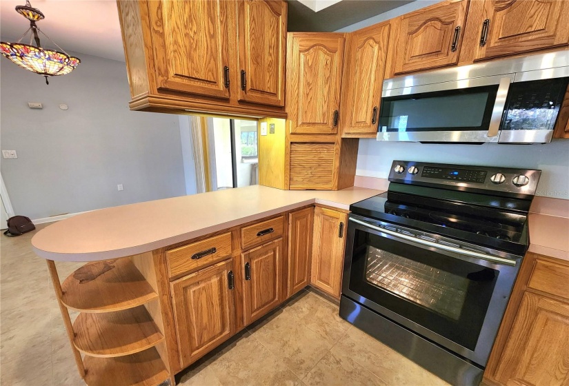 appliance cabinet with outlet to left of stove and a lazy susan