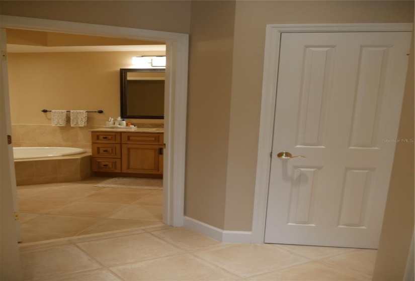 The view from the primary bedroom to the ensuite bath with a linen closet in front.