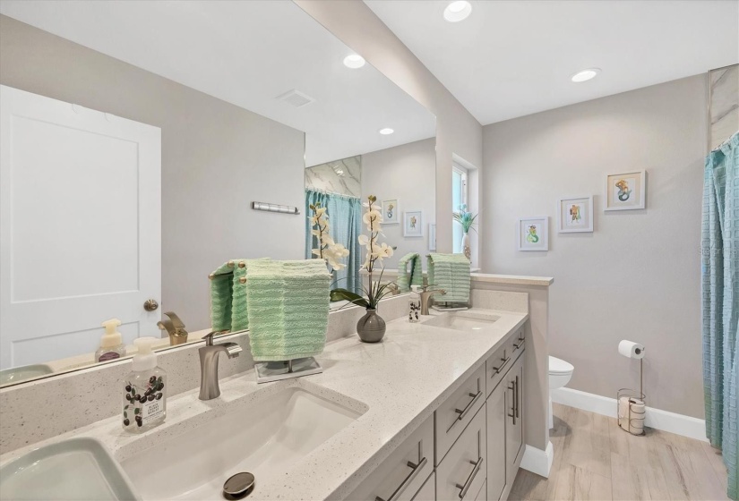 The ensuite bathroom offers double sinks and ample cabinet storage.