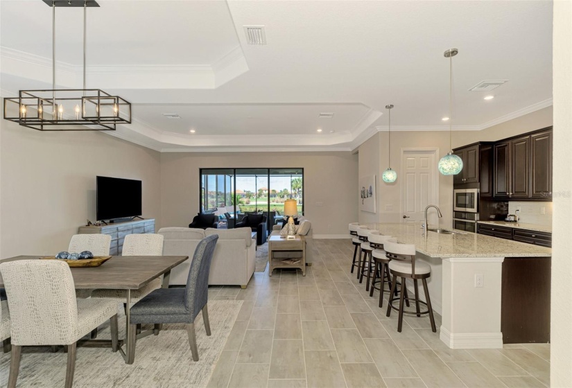 Kitchen on the right with 12' Island, dining room and living room with doors to the lanai