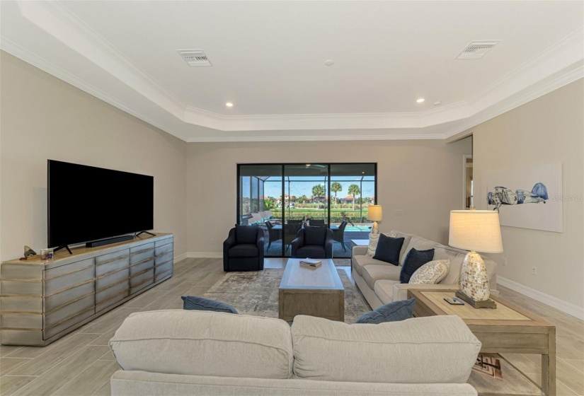 Living room looks out over lanai/water and golf course