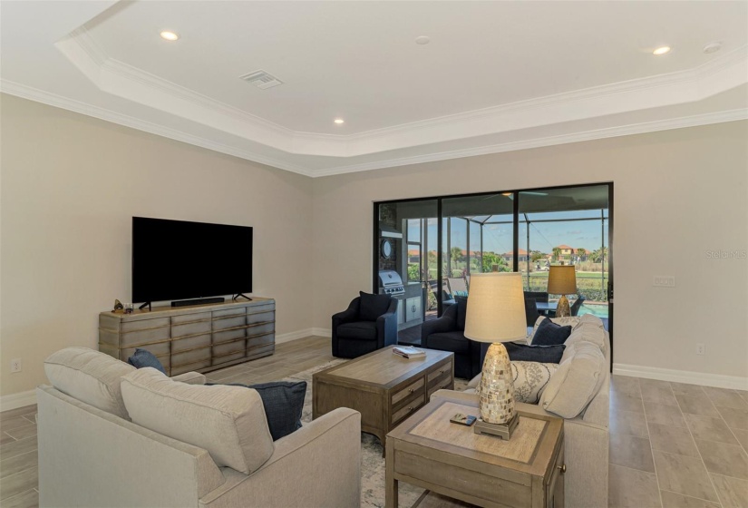 Living room looks out over lanai/water and golf course