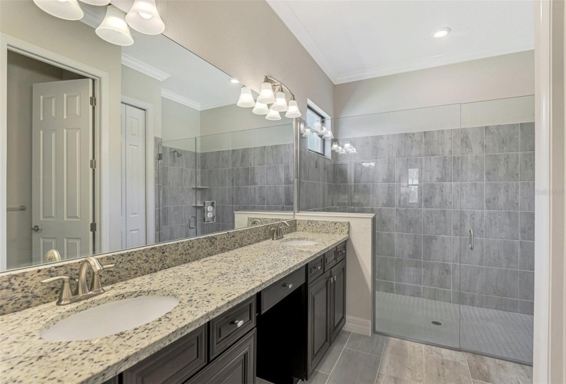 The ensuite bath has dual sinks and a vanity area for make-up