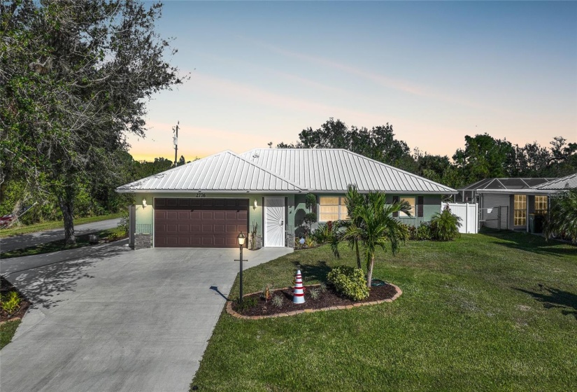 Front of home showing off circle drive and beautiful tree