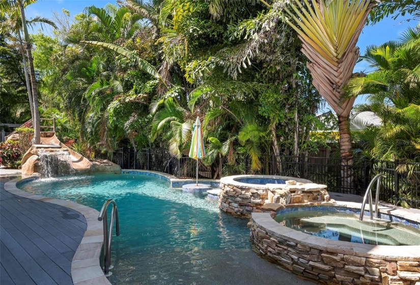 Pool with waterfall, a slide and spa