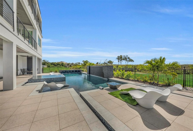 Luxurious pool and spa with fire pit complete the outdoor living space.